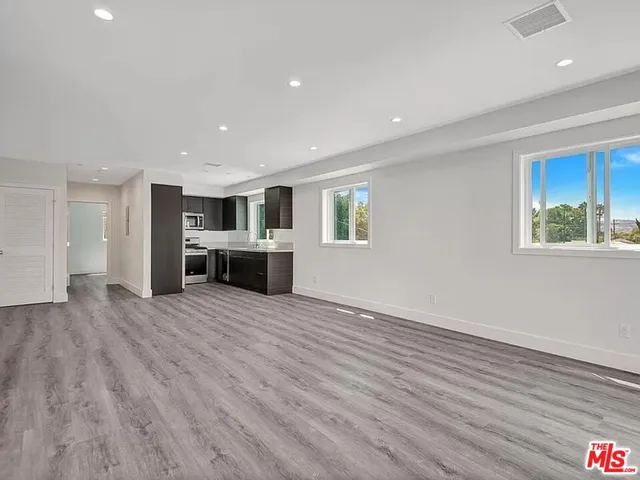 a view of a livingroom with a furniture wooden floor and windows