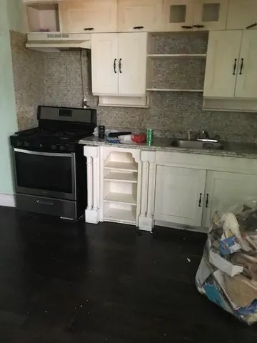 a kitchen with granite countertop a stove and a microwave