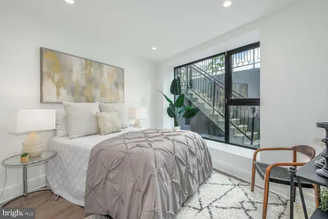 a bed sitting in a bedroom next to a window