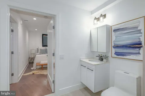 a bathroom with a sink and mirror with toilet