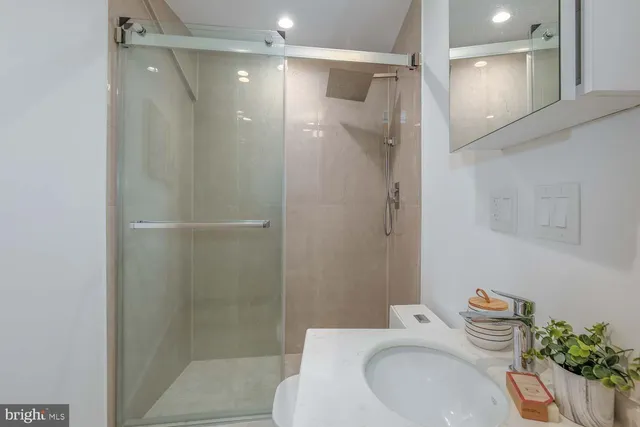 a bathroom with a sink a toilet and shower