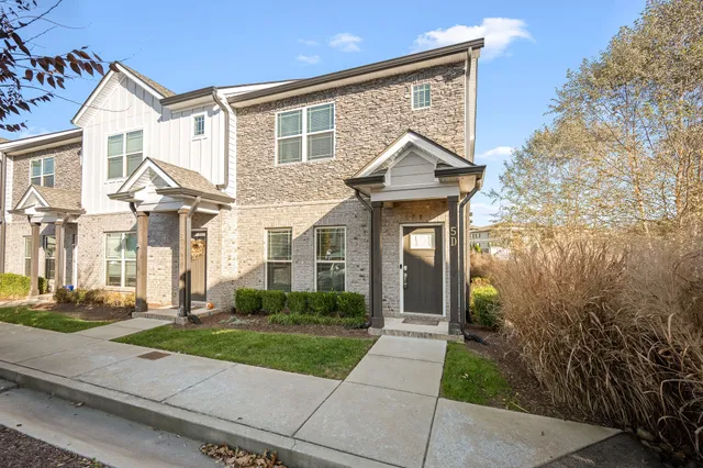 a front view of a house with a yard and potted plants
