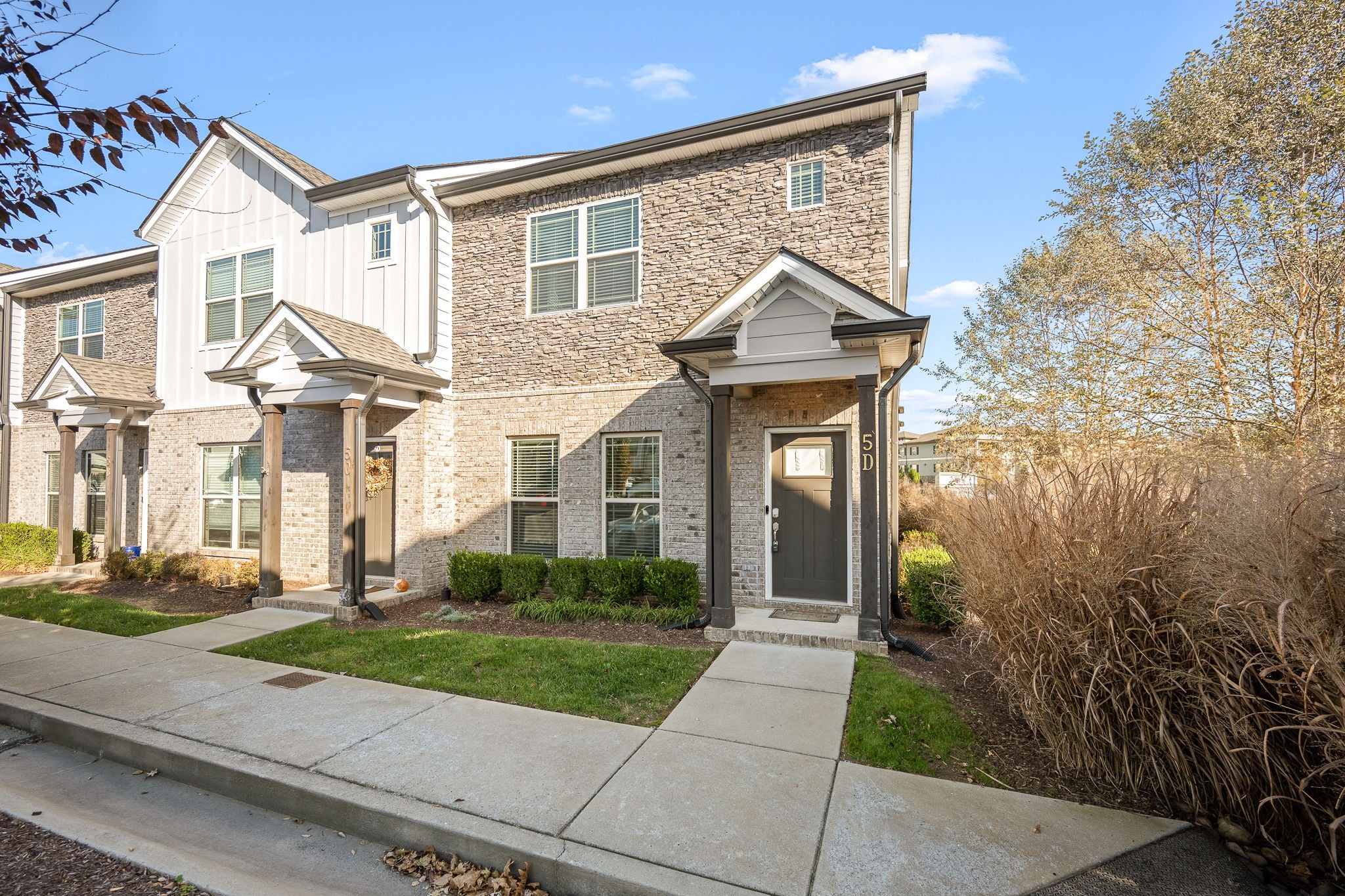 a front view of a house with a yard and potted plants