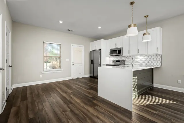 a kitchen with stainless steel appliances granite countertop a refrigerator a stove a sink and a oven