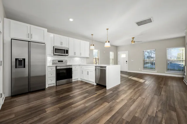 a kitchen with stainless steel appliances granite countertop a stove a sink and a microwave