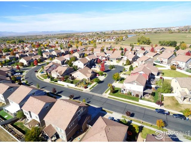an aerial view of a city with lots of residential buildings and ocean view in back