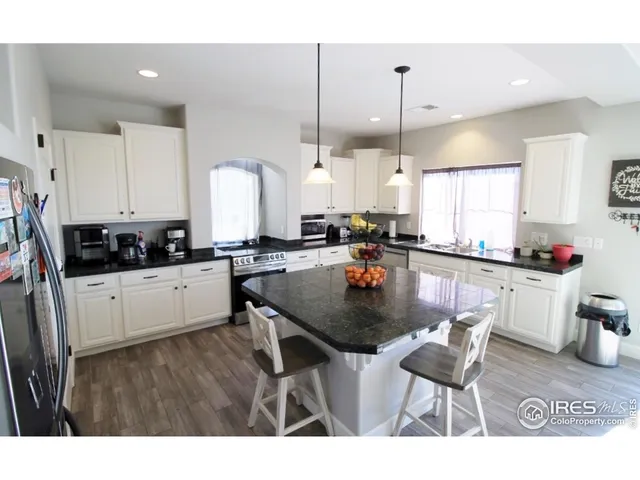 a kitchen with stainless steel appliances granite countertop a kitchen island a white cabinets a sink a counter top space and cabinets