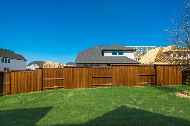 a view of a backyard with wooden fence