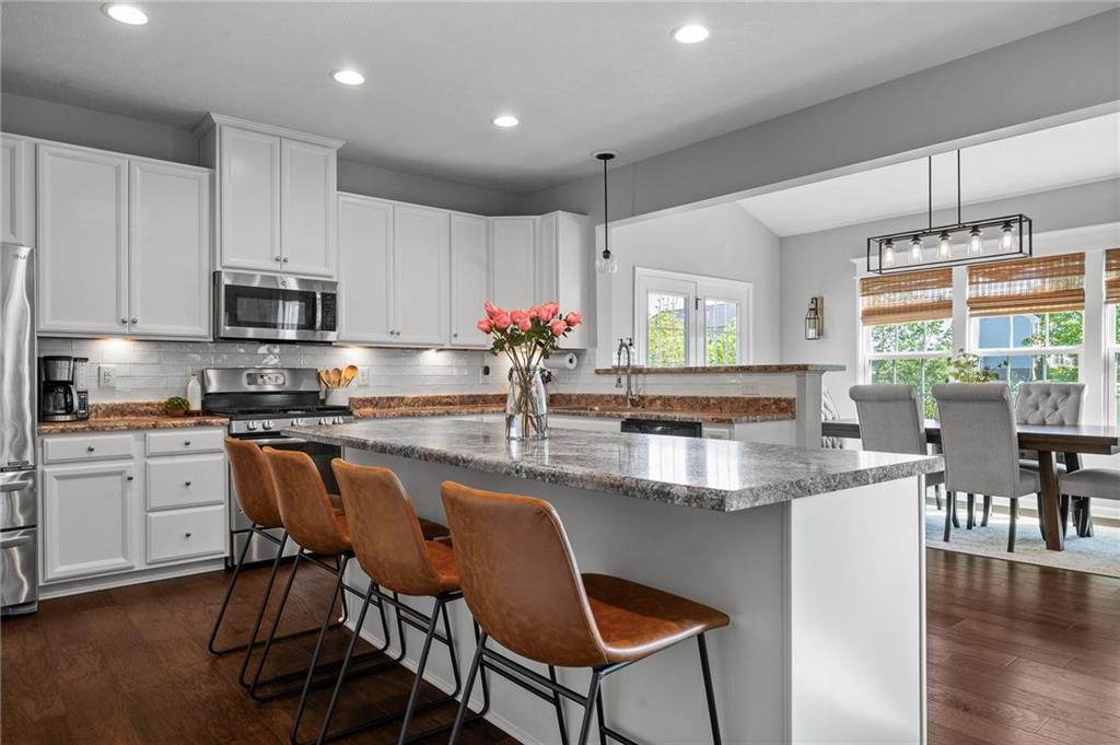 110 Brook Side Drive Clinton, PA 15026 - Photo 21 of 49 a kitchen with kitchen island granite countertop wooden floors and white appliances