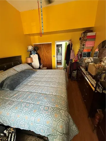a bedroom with a bed and wooden floor