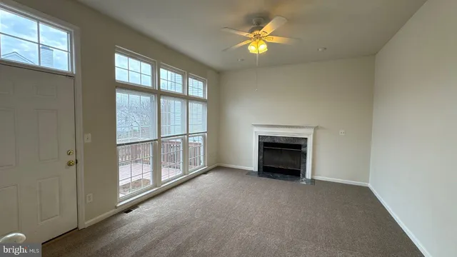 an empty room with windows and fireplace