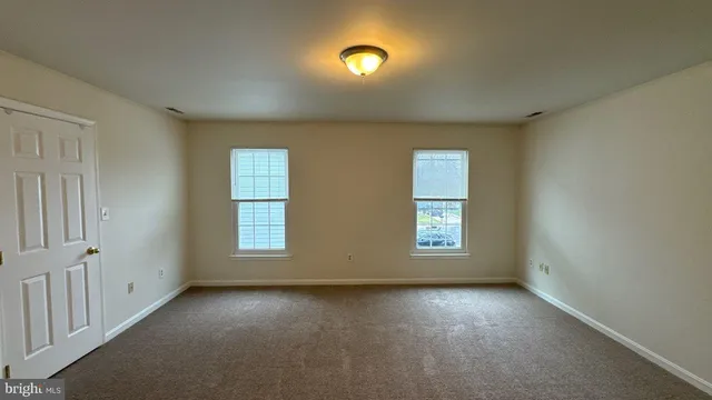 an empty room with windows and closet