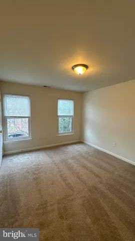an empty room with a window and fireplace