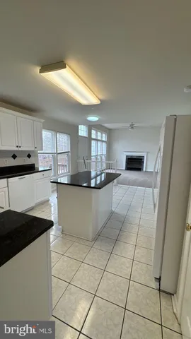 a kitchen with granite countertop a stove a sink and a refrigerator