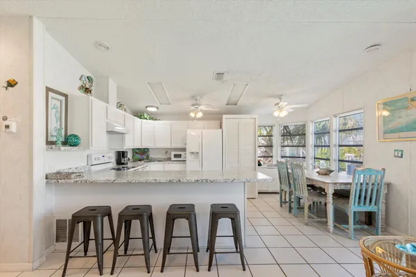 a kitchen with stainless steel appliances granite countertop a table and chairs in it