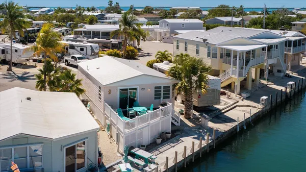 an aerial view of a house with a garden and lake view