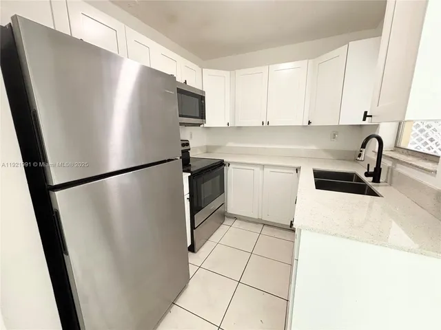 a kitchen with stainless steel appliances a refrigerator sink and cabinets