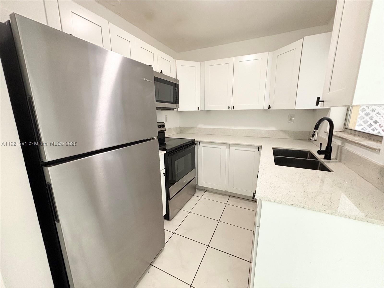a kitchen with stainless steel appliances a refrigerator sink and cabinets