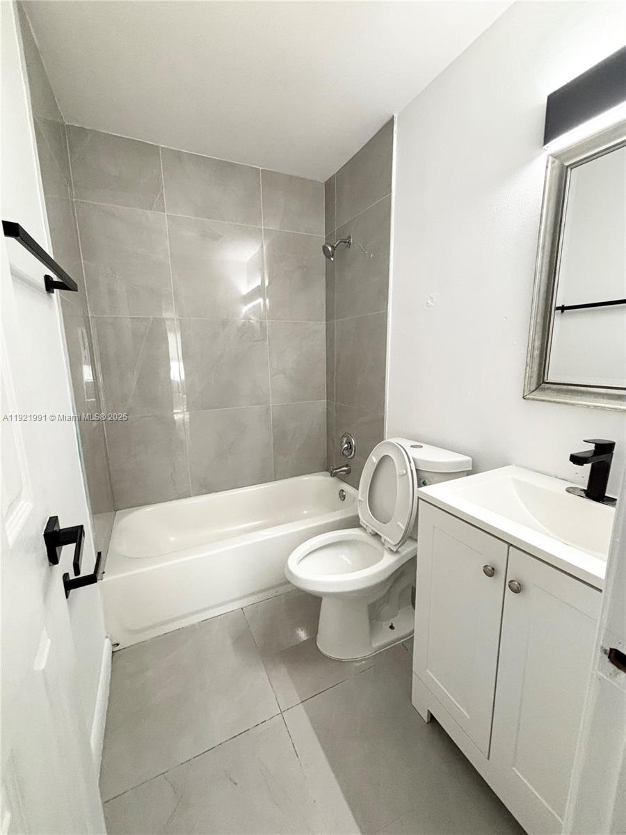3203 Northwest 5th Terrace, Unit 4 Pompano Beach, FL 33064 - Photo 8 of 8 a bathroom with a sink a toilet and a bathtub