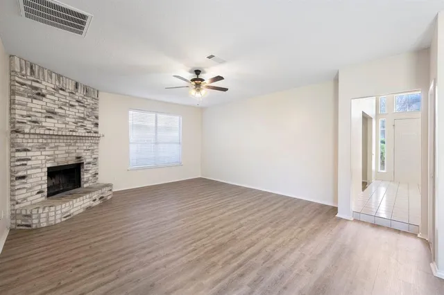 an empty room with windows and fireplace