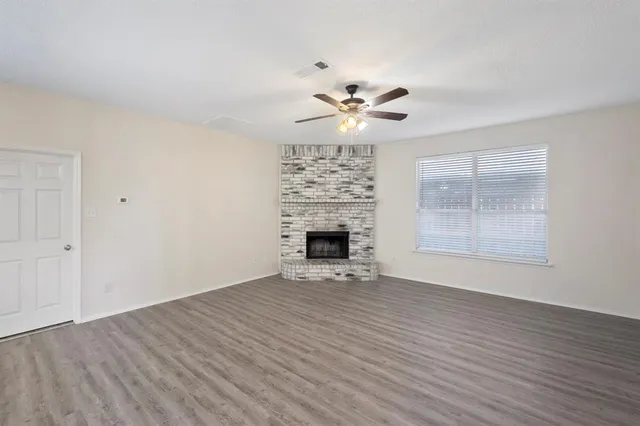wooden floor fireplace and windows in an empty room