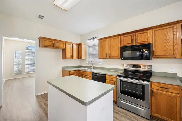 a kitchen with stainless steel appliances a stove microwave and sink