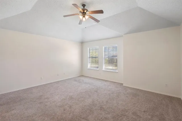 an empty room with windows and fan