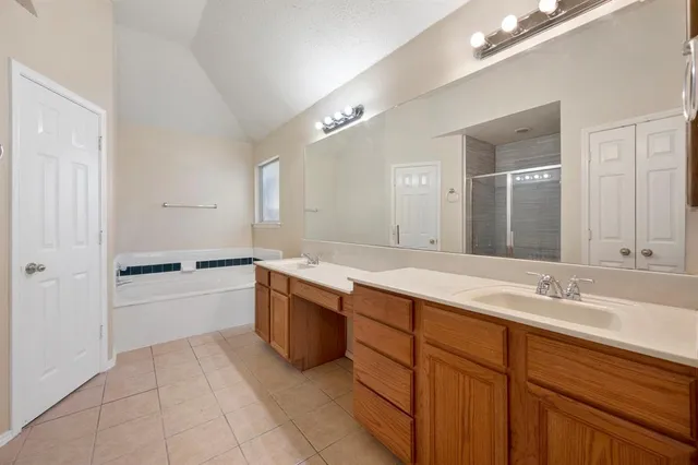a spacious bathroom with a granite countertop sink mirror and bathtub