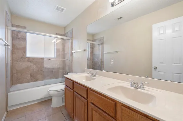 a bathroom with a bathtub shower sink vanity mirror and toilet