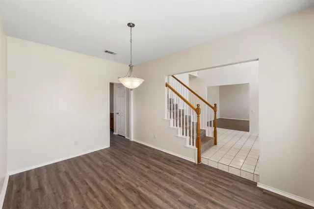 a view of a hallway with wooden floor and entryway