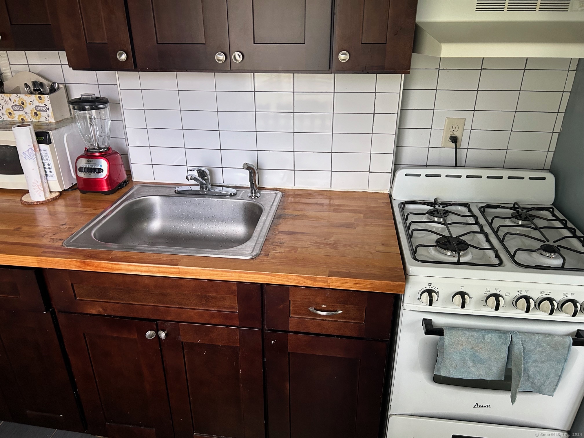 260 Success Avenue, Unit 21 Bridgeport, CT 06610 - Photo 5 of 15 a kitchen with a stove and cabinets