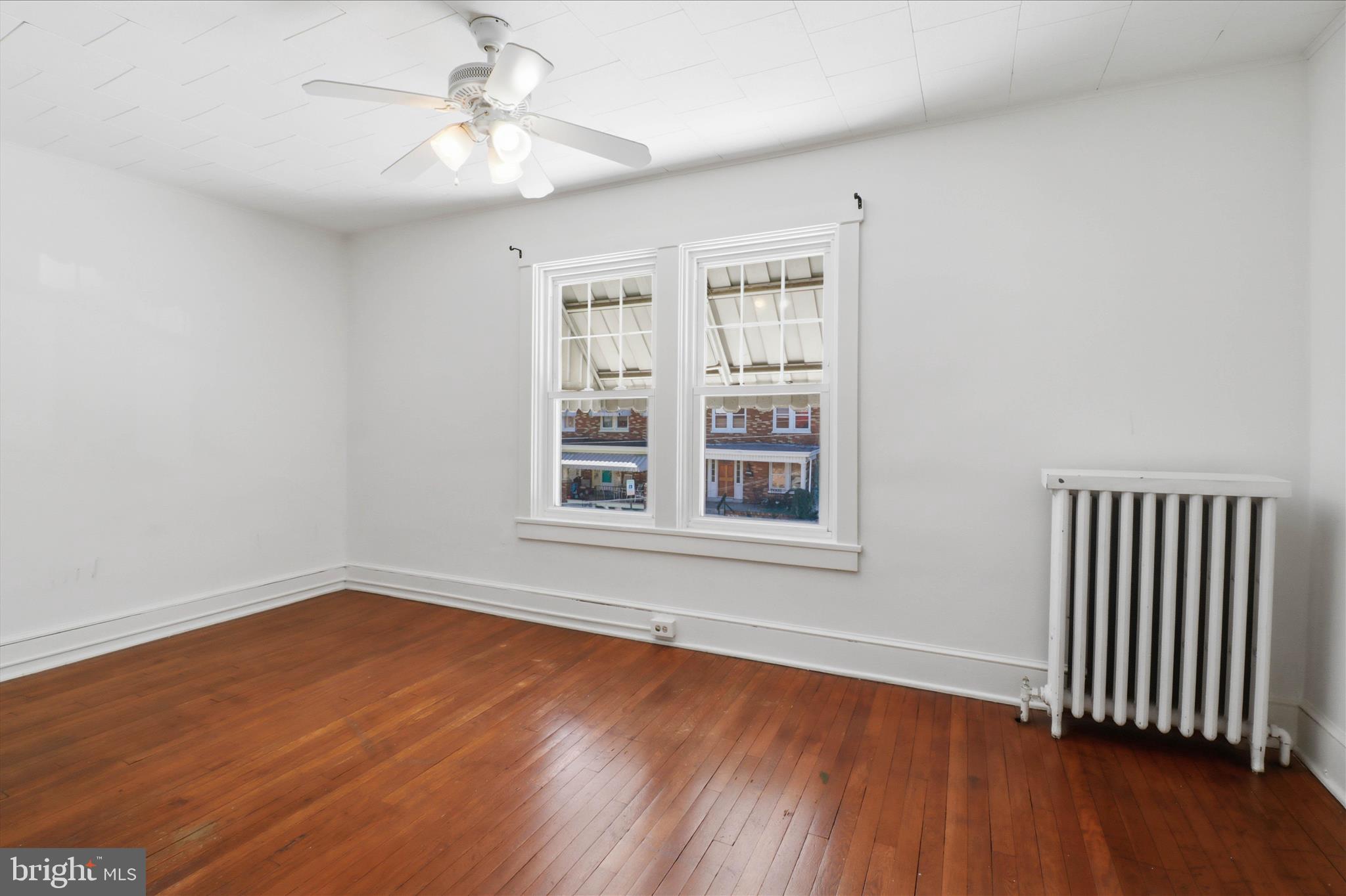521 Hamilton Street Lancaster, PA 17602 - Photo 23 of 44 an empty room with wooden floor chandelier fan and windows
