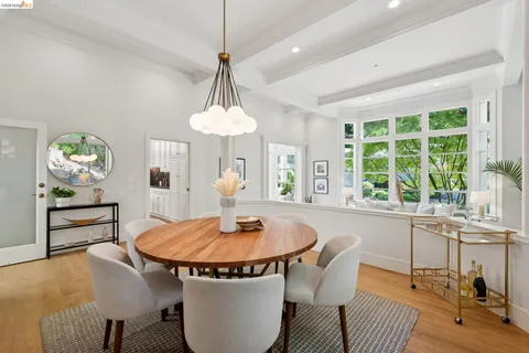a dining room with chandelier and wooden floor