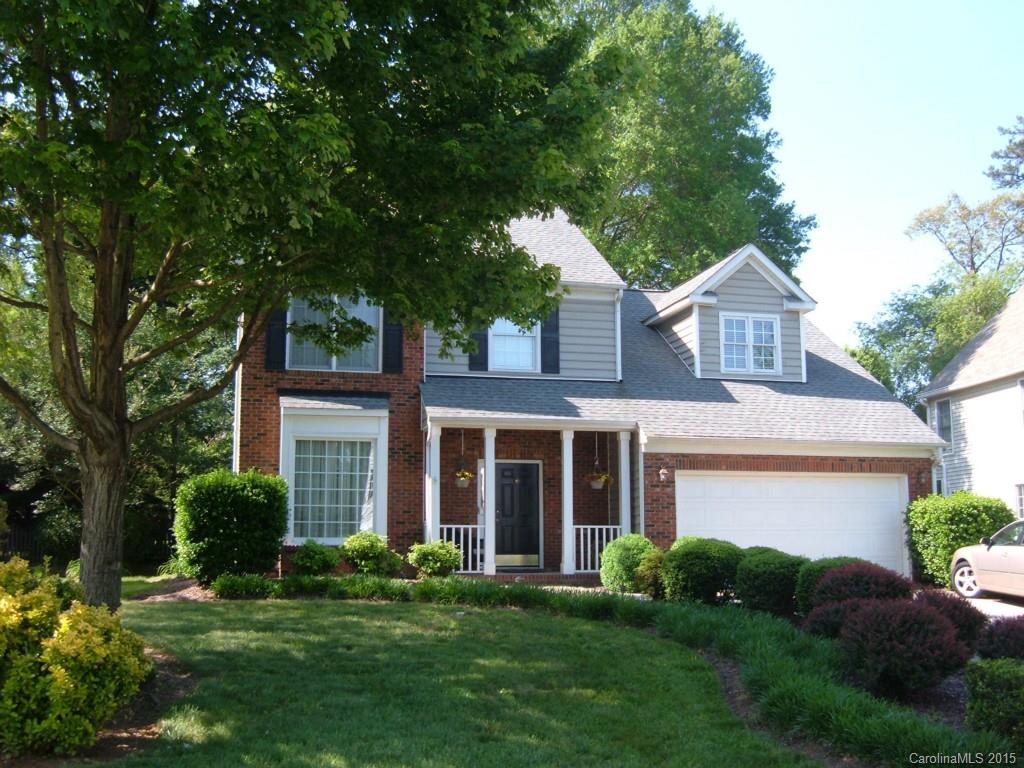 a front view of a house with a yard and potted plants