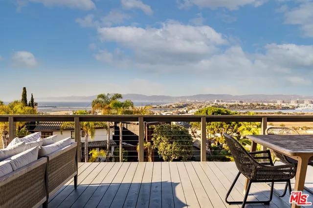 a roof deck with a dining table and chairs with wooden floor