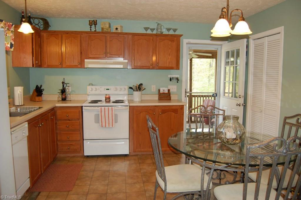 664 Spainhour Road King, NC 27021 - Photo 6 of 12 Large eat-in kitchen, all appliances remain! Connects to screen porch. Laundry room behind slatted door.