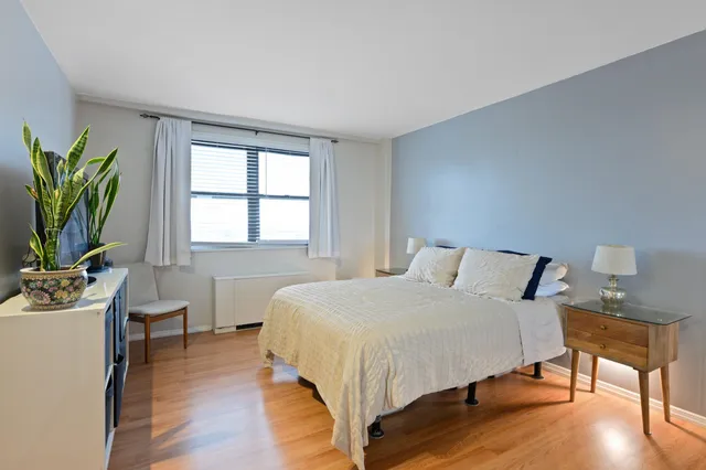 a bedroom with a bed window and table