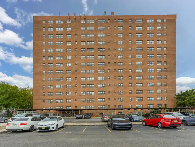 a view of a building and a cars parked on the side of the road