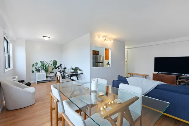 a living room with furniture a flat screen tv and a dining table