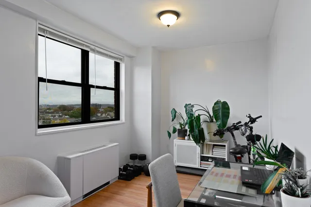 a view of a workspace with furniture and a potted plant