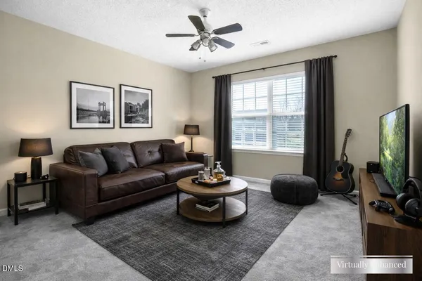 a living room with furniture a flat screen tv and a window