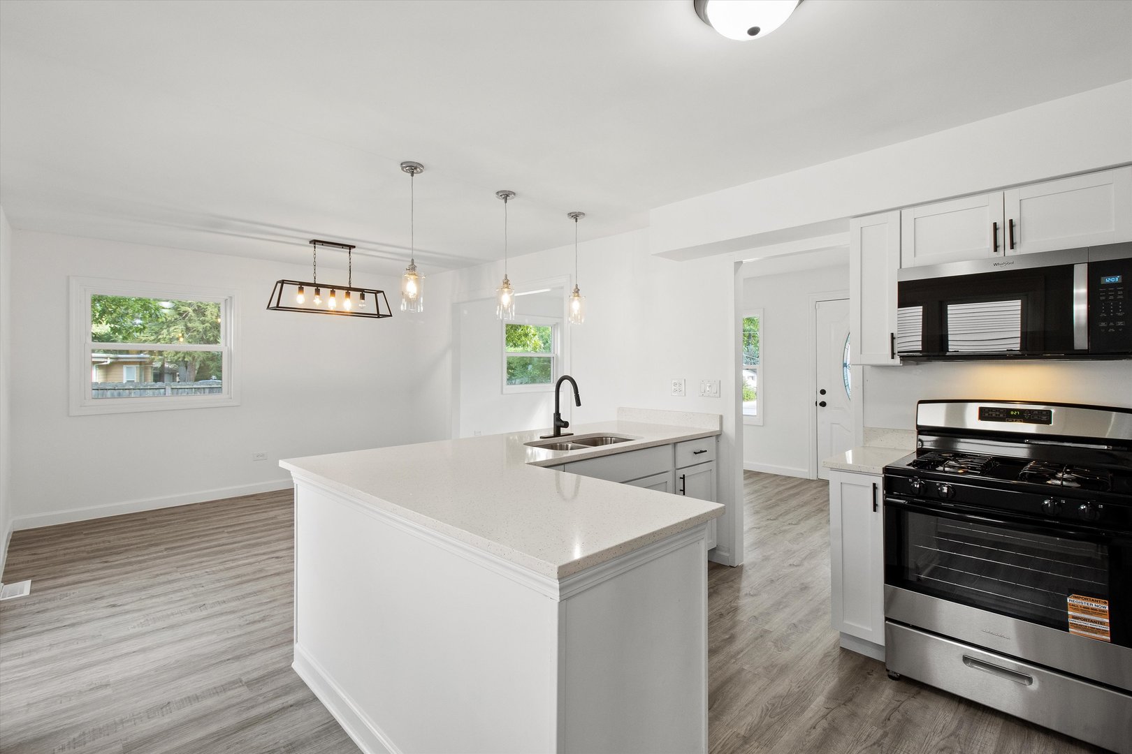 33448 North Greentree Road Grayslake, IL 60030 - Photo 9 of 49 a kitchen with stainless steel appliances a stove a microwave and white cabinets