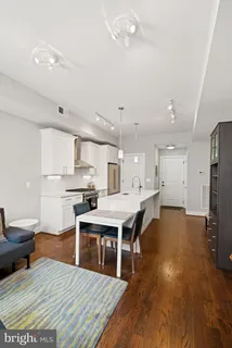 a kitchen with granite countertop a table chairs microwave and cabinets