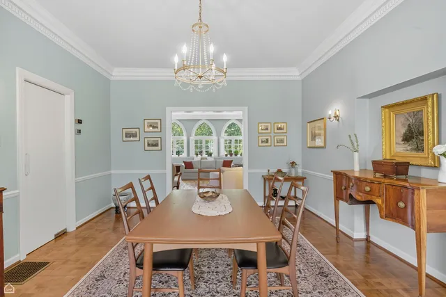 a view of a dining room with furniture a chandelier and wooden floor