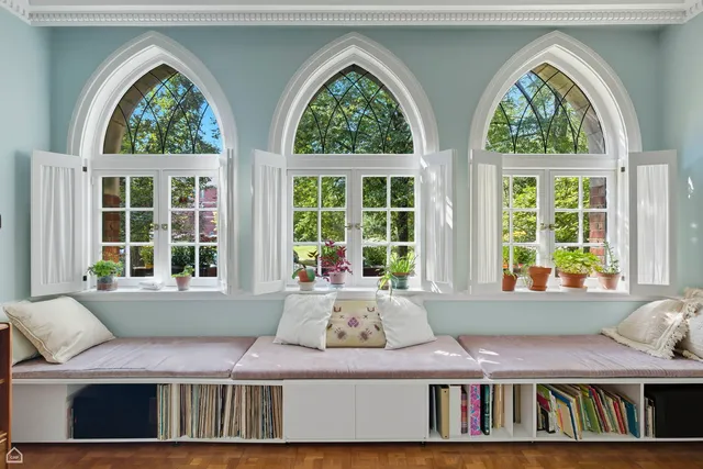 a room with large window and a bed