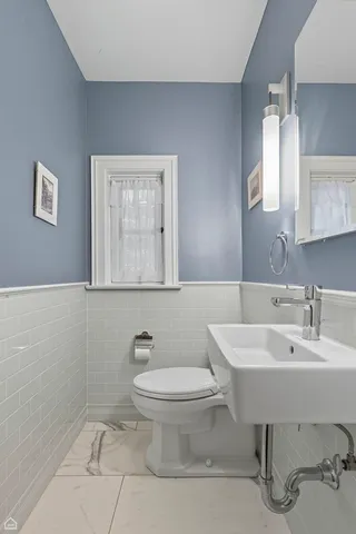 a bathroom with a toilet sink and mirror