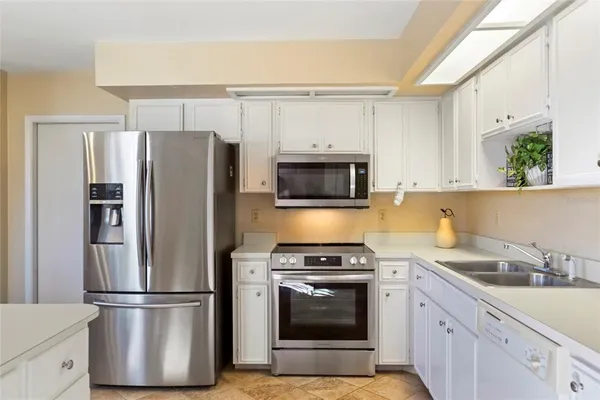 a kitchen with appliances a refrigerator and cabinets
