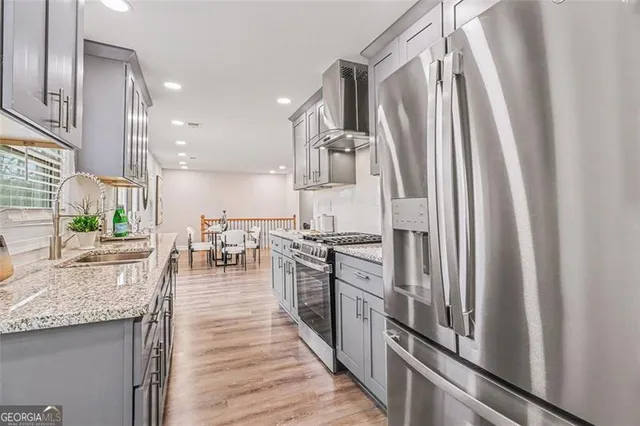 a kitchen with stainless steel appliances granite countertop lots of counter top space and wooden floor