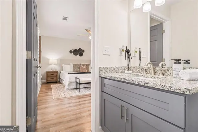 a bathroom with a granite countertop sink a toilet and shower