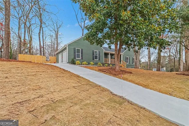 a front view of a house with a yard covered in snow